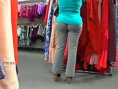Sensual babe in gray pants walks around the store jiggling