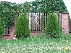 Die dunkelhaarige Sahne pinkelt auf Gras in der Nähe des Flughafens